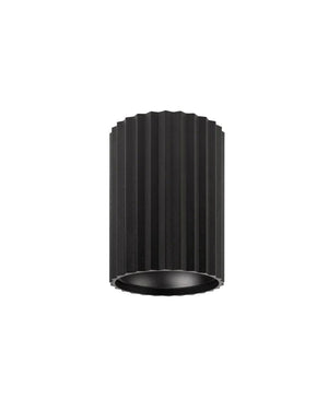 Small black ribbed cylindrical light fixture on a white background