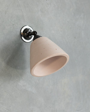 Beige cone-shaped wall light fixture on a gray concrete wall