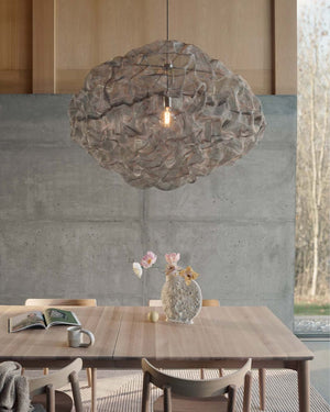 Modern dining room with a textured Artistic Mesh Pendant, wooden table, and chairs.