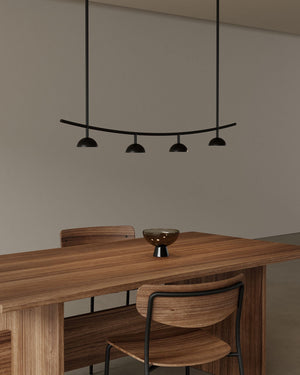 Dining area with wooden table and chairs under a modern pendant light.