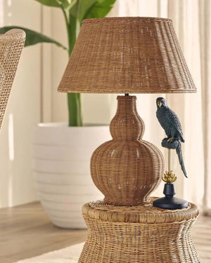 Wicker table lamp with a parrot figurine on a wicker side table.