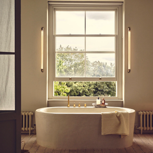 Cylindrical Linear Reeded Glass Wall Light | Lighting Collective | antique brass in a bathroom on both sides of a window