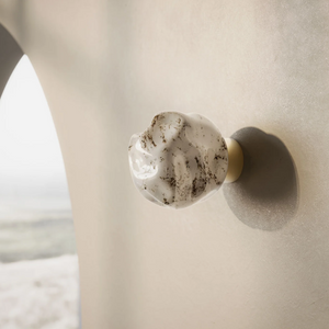 Refined Textured Glass Wall Light on a grey wall with natural brass structure