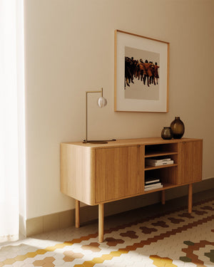 Wooden sideboard against a wall with a framed picture above it and a Delicate Ridged Glass Spherical Table Lamp