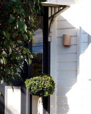 Exterior Organic Raw Ceramic Wall Light | Nudie at the front of a house