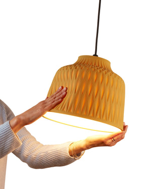 Person holding a Ochre Silicone pendant light against a white background