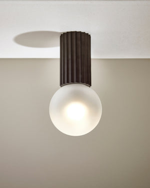 Ceiling light fixture with a round bulb on a neutral background