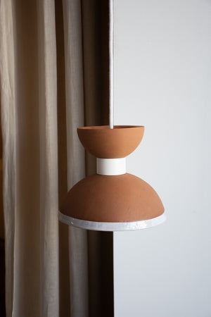 Ceramic lamp with brown shade and white base against a neutral background
