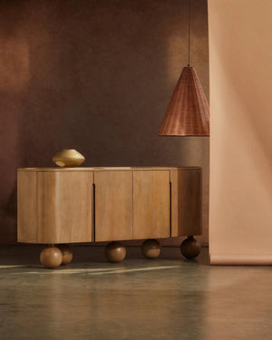 Wooden sideboard with a rattan pendant lagainst a brown wall