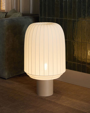 White textured table lamp on a wooden floor in a living area