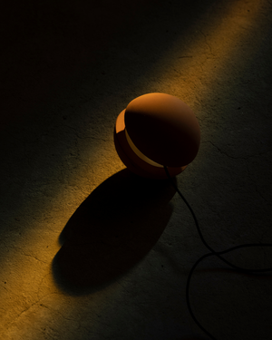 Small lamp casting a shadow on a dark surface