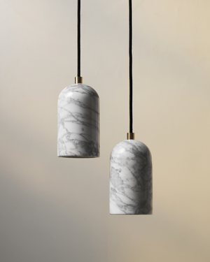 Two marble-textured pendant lights hanging against a beige background
