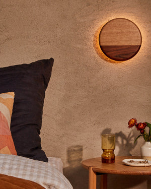 Circular timber wall light in a bedroom