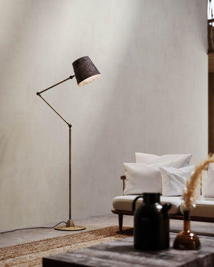 Industrial reporter floor lamp in a living room near a modern couch