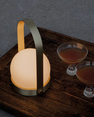 Modern brass lamp on a dark wooden tray