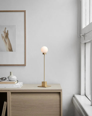 Modern interior with a desk, Mid-Century Modern Orb Table Lamp, and framed artwork on a light gray wall.