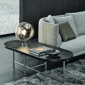 Mouth-Blown Double Lens Table Lamp | Lighting Collective | clear silver on a side table near a sofa