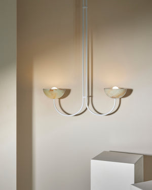 Modern pendant with two lights on a plain wall.