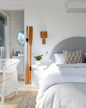 Organic Timber Wall Sconce With Woven Shade In a Coastal Style Bedroom