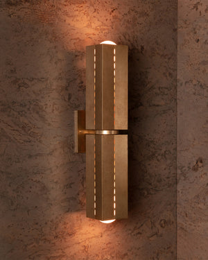 Gold wall sconce on a textured wall