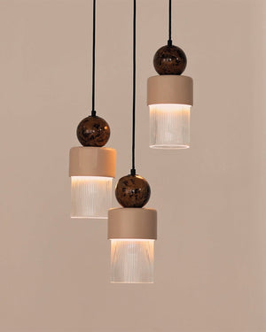 Three Ribbed Brown Marble Pendant lights with beige and brown design on a beige background