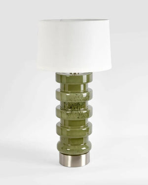 Table lamp with a green glass base and white shade on a white background