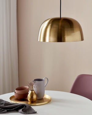Scandinavian Brass Dome Pendant suspended over a round dining room table  Lighting Collective 