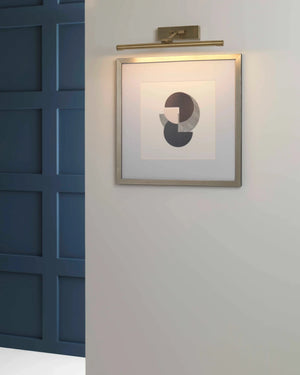 Wall-mounted light fixture on a white wall with a framed abstract art piece.
