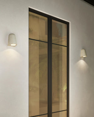 Modern outdoor wall lights on a building facade with glass panels.