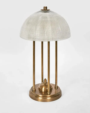 Table lamp with brass base and textured white shade on a light gray background