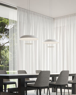 Two white aluminium disc pendant light suspended above a dining table in a minimal interior