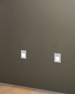 Two square wall lights on a dark gray wall.