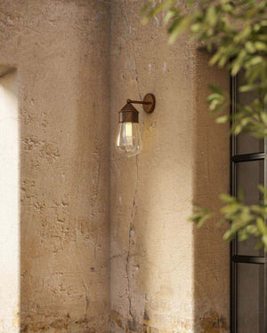 Antique Brass & Copper Wall Light placed outside of a country house