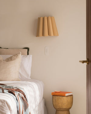 Modern bedroom with wooden wall lamp installed above bedside table