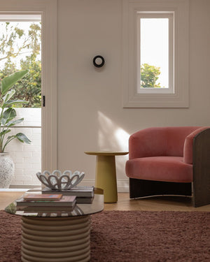 A modern living room with vibrant furniture and a timber wall sconce