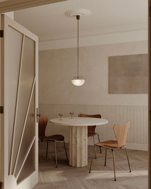 Dining room with a round table and chairs, featuring a pendant light.