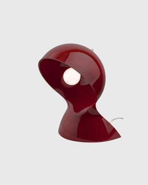 Mid-century inspired lamp in a glossy ruby red finish on a grey background