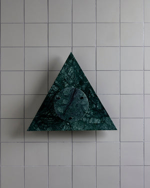 Triangular green marble wall sconce on a tiled wall