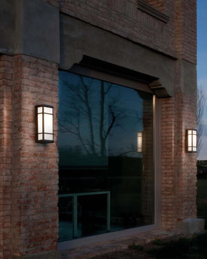 Brass-Framed Box Wall Light mounted on outdoor brick entrance at dusk with illuminated white panels
