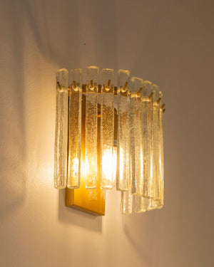Glass and brass panel wall light turned on