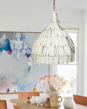 White ceramic tapered shard pendant lighting in a bright dining area above table next to abstract horse painting
