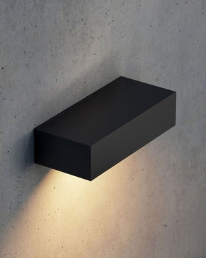A coastal grade slim wall lighting mounted on a textured wall with a warm downlight