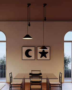 Dining area with black pendant lights, star and moon wall art, and a table with chairs.