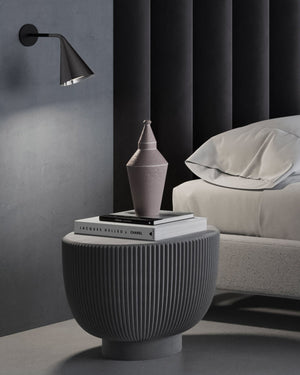 Conical wall light in a bedroom next to the bed