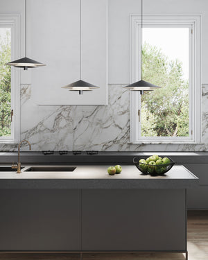 Three contemporary floating disc pendant light hanging above a grey marble kitchen island