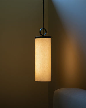 Contemporary linen cylindrical pendant styled with the light on