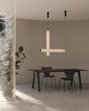Modern dining area with a minimalist pendant light fixture, black table, and chairs.