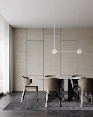 Modern dining room with a round table and chairs under pendant lights.