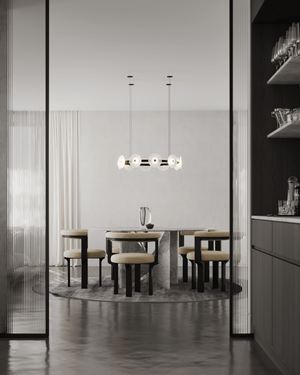 Modern dining room with a round table and chairs, featuring a stylish chandelier.
