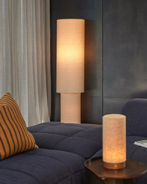 Floor and table lamp with a linen beige shade in a living room setting.